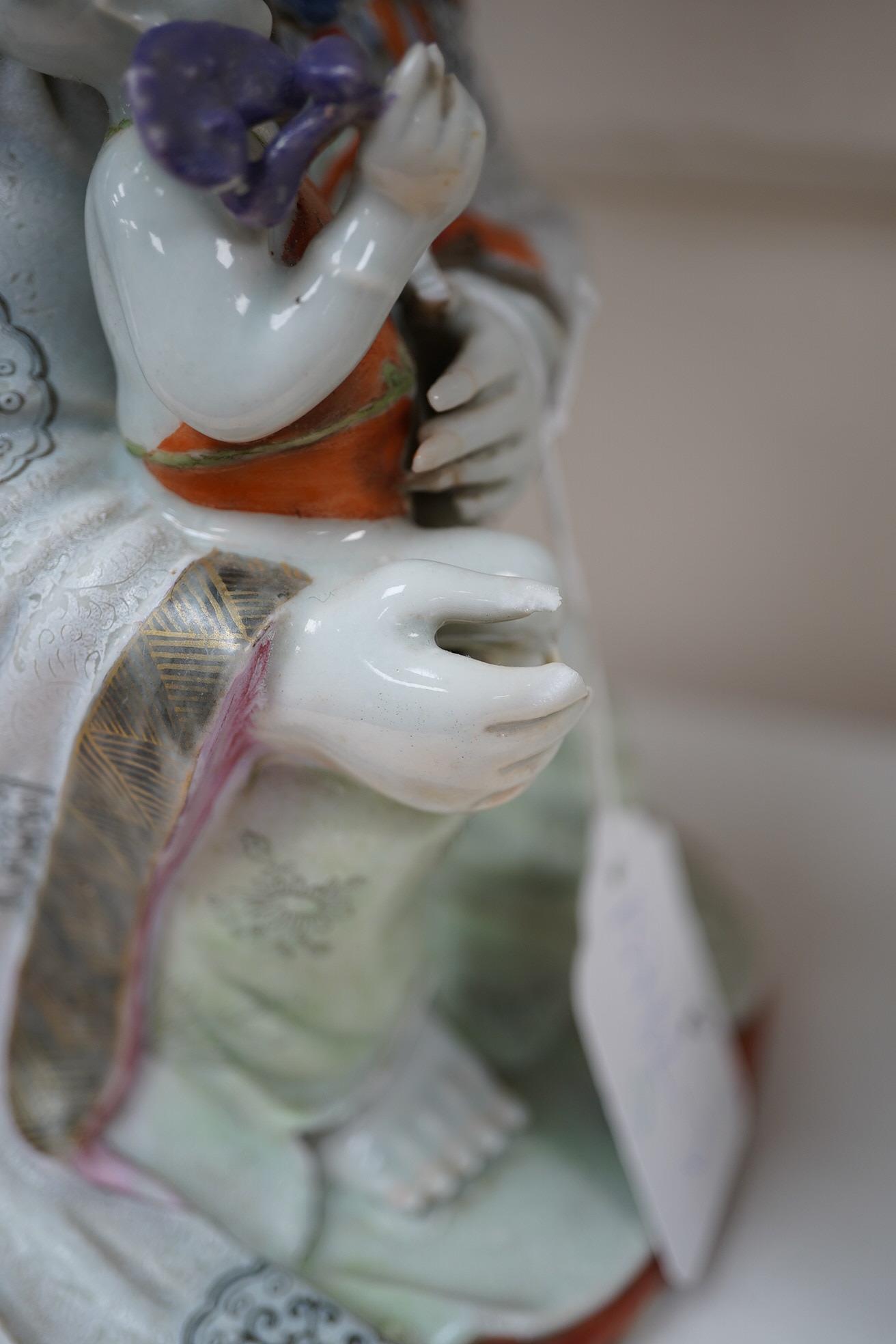 A Chinese enamelled porcelain group of Guanyin holding a child, Qianlong period